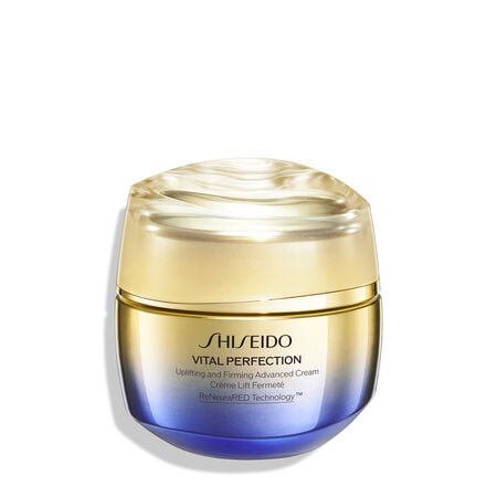 A round, gold-and-purple-colored jar of Shiseido Vital Perfection Uplifting and Firming Advanced Cream. The closed jar features the Shiseido logo, product name, and the words "ReNeuraRED Technology." 