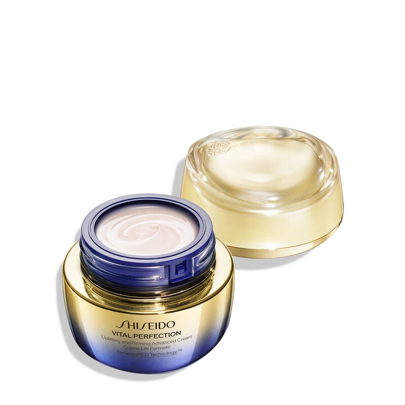 An open jar of Shiseido Vital Perfection Uplifting and Firming Advanced Cream. The jar reveals the creamy white product inside. It’s labeled with the product name, as well as the words "ReNeuraRED Technology."  